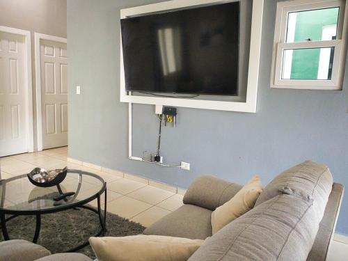 a living room with a couch and a flat screen tv at Disfruta y siéntete como en casa in San Miguel