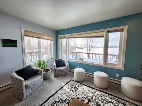 uma sala de estar com duas cadeiras e duas janelas em Hidden Lakefront Villa em Fairbanks