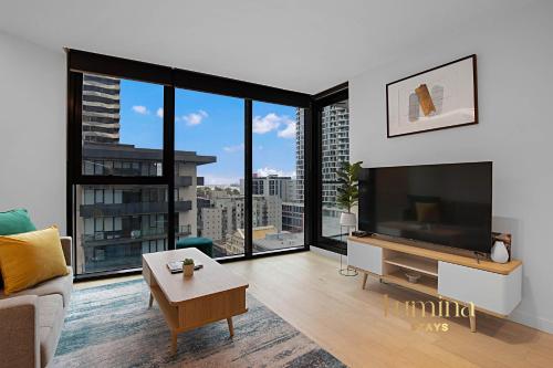 a living room with a large flat screen tv at Lumina Stays - Lighthouse in Melbourne