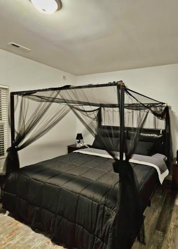 1 dormitorio con cama negra con dosel en Book now for a wonderful stay, at Casa Spanaway!, en Spanaway