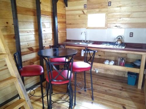 una cocina con mesa y taburetes en una cabaña en CABAÑA MINCHY, en Mazamitla