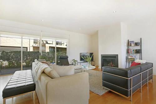 a living room with a couch and a fireplace at Sorrento Del Mar in Sorrento