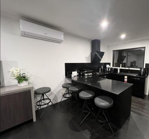 - une cuisine avec un comptoir et des tabourets dans l'établissement New Lynn Dream guest house, à Auckland