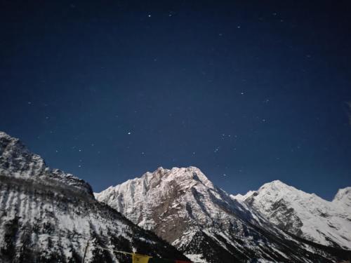 a night view of a snow covered mountain at SNOWFLAKE Homestay in Gondla