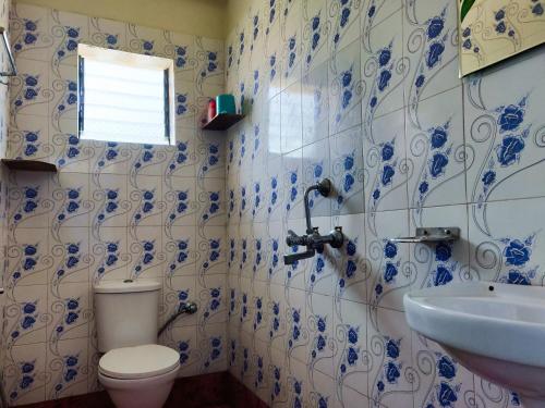 a blue and white bathroom with a toilet and a sink at Morjim Sunset Guesthouse - 300 meter to Morjim Beach in Morjim