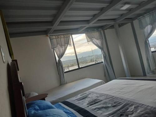 1 dormitorio con cama y ventana en Terraza en las Nubes, en Ibarra