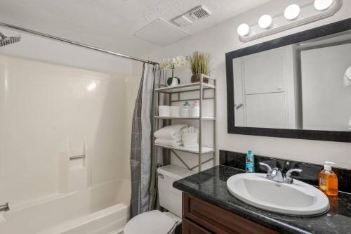 a bathroom with a sink and a toilet and a mirror at Bello condominio con vista al mar, jacuzzi interno in Galveston