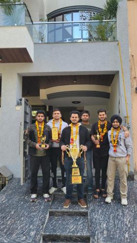 um grupo de homens posando para uma foto com um troféu em Anirudh Homestay em Agra