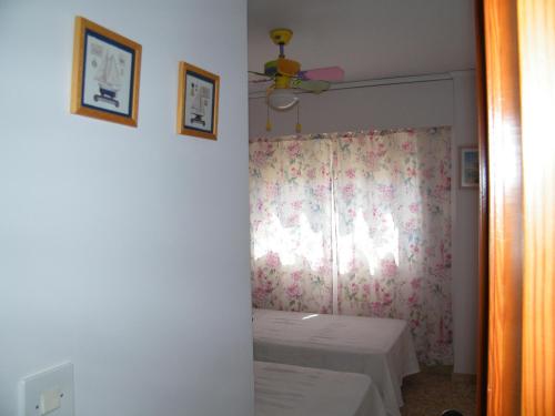 Habitación con cama y ventana con cortina en Apartamento Playa de Gandía, 3 dormitorios, 7 personas - ES-314-8 en Gandía