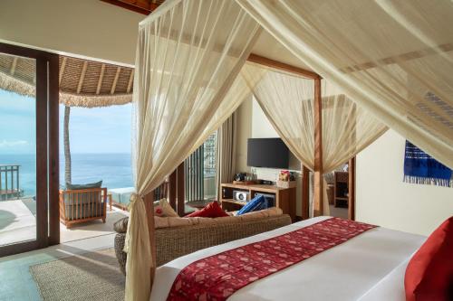 a bedroom with a bed and a view of the ocean at Kalandara Resort Lombok in Senggigi