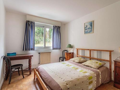 1 dormitorio con cama, escritorio y ventana en Appartement Ciboure, 4 pièces, 6 personnes - FR-1-4-687, en Ciboure