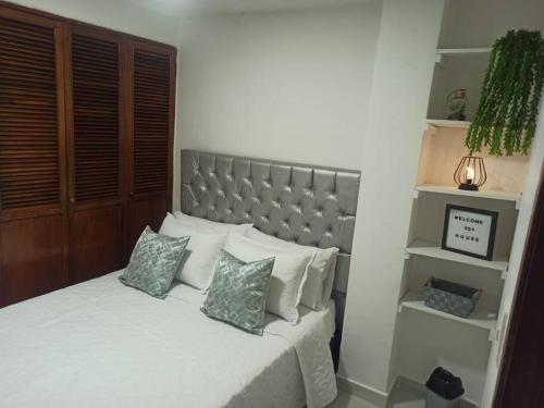 - une chambre avec un lit blanc et 2 oreillers dans l'établissement Apartamento céntrico en Cartagena, à Carthagène des Indes
