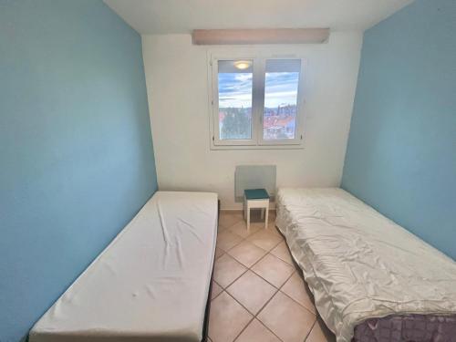 ein Zimmer mit 2 Betten und einem Stuhl darin in der Unterkunft Appartement Le Grau-du-Roi, 3 pièces, 4 personnes - FR-1-716-66 in Le Grau-du-Roi