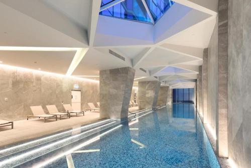 a swimming pool in a building with a glass ceiling at Lumina Stays - Lighthouse in Melbourne