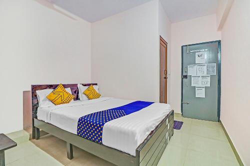 1 dormitorio con 1 cama con almohadas amarillas y azules en SPOT ON Sln Comforts Near Nagasandra Metro Station, en Bangalore