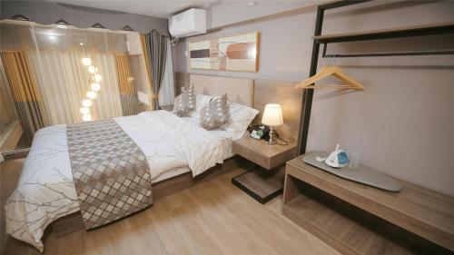 a bedroom with a bed and a desk and a bed sidx sidx sidx at Serveyou International Apartment Hotel - Free Airport Pickup & Free Canton Fair shuttle & Paid City Tour in Zengcheng