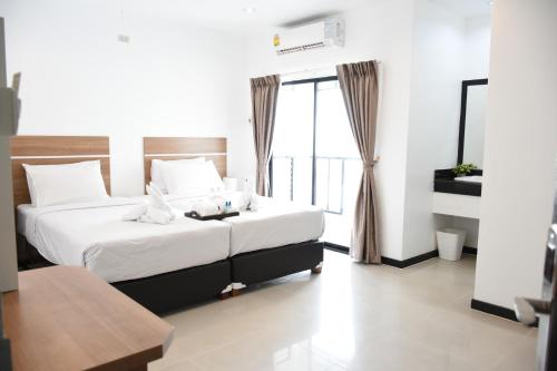 a bedroom with a bed and a large window at Basaya Laemchabang in Ban Laem Chabang