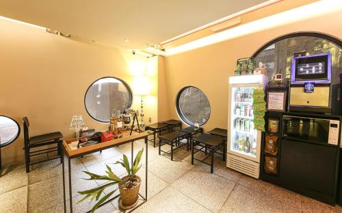 a room with a refrigerator and a table and chairs at 뮤트호텔 대연 MUTE HOTEL Daeyeon Busan in Busan