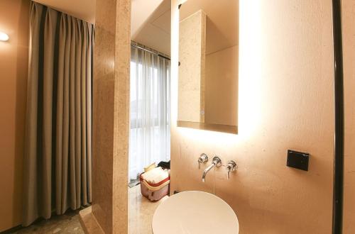 uma casa de banho com um lavatório e um espelho em MUTE HOTEL em Busan