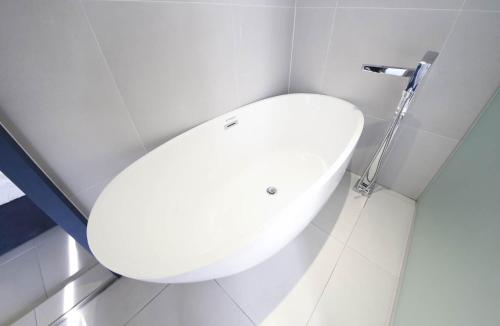 a white sink in a bathroom with a shower at 뮤트호텔 대연 MUTE HOTEL Daeyeon Busan in Busan