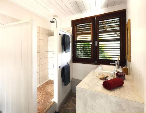 La salle de bains est pourvue d'un lavabo et d'un comptoir avec évier. dans l'établissement Villa Vue Marine, au Diamant