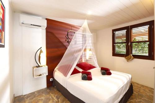 - une chambre avec un lit doté d'une moustiquaire dans l'établissement Villa Vue Marine, au Diamant