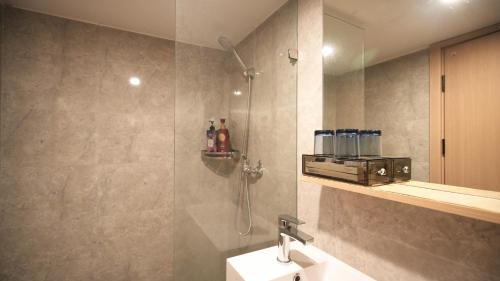a bathroom with a shower with a sink and a shower at Serveyou International Apartment Hotel - Free Airport Pickup & Free Canton Fair shuttle & Paid City Tour in Zengcheng