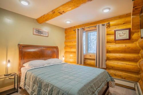 a bedroom with a bed in a room with wooden walls at Tucked Away Timbers in Fairbanks