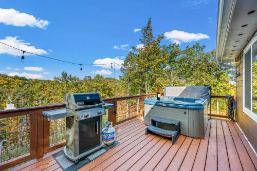 a grill and a barbecue on a deck at Ultimate Summer Escape! Cabin-Hot Tub-Cozy-Views-Minutes2Fun in Sevierville