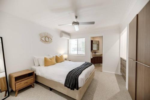 a white bedroom with a bed and a window at The Seaglass Villa Private Pool and Sauna in Sunshine Beach