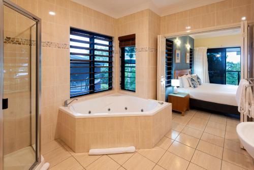 a large bathroom with a tub and a bed at Anchorage Apartments on Hamilton Island by HIHA in Hamilton Island