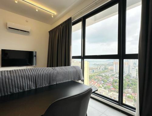 Zimmer mit einem großen Fenster, einem Bett und einem TV in der Unterkunft Urban Pleasure Suites Central of GeorgeTown Jelutong in Jelutong