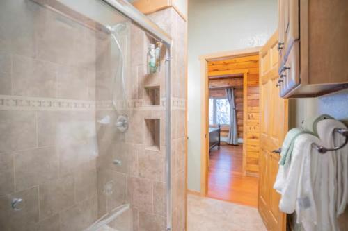 a bathroom with a shower with a glass door at Tucked Away Timbers in Fairbanks