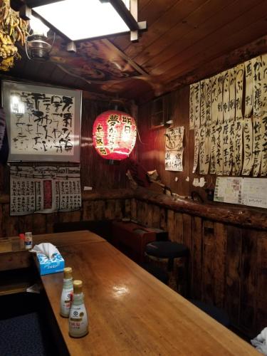 a wooden table in a restaurant with signs on the wall at Furano Mount Villa in Furano