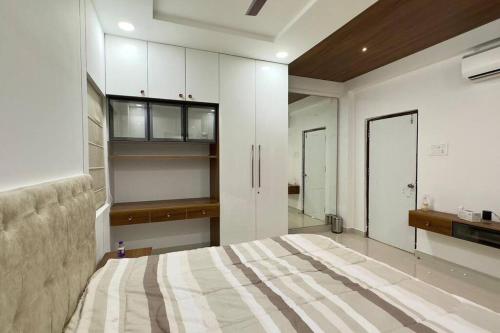 ハイデラバードにあるBrand New Luxurious Independent Villaのベッドルーム1室(ベッド1台付)、キッチン(キャビネット付)