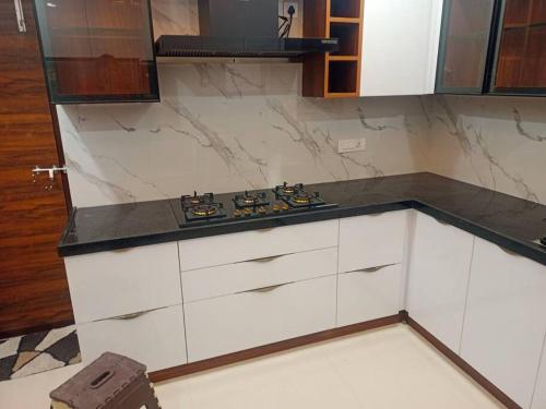 a kitchen with white cabinets and a counter top at Brand New Luxurious Independent Villa in Hyderabad