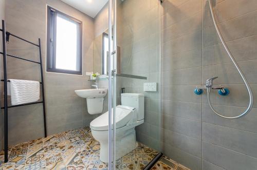 La salle de bains est pourvue d'une douche et de toilettes. dans l'établissement 泥house, à Luodong