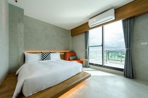 1 dormitorio con cama y ventana grande en 泥house, en Luodong