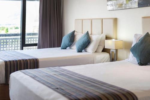 a hotel room with two beds and a balcony at Rydges Esplanade Resort Cairns in Cairns