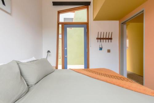 a white bed with an orange blanket on top of it at Josh Schweitzer's Monument House Joshua Tree in Joshua Tree