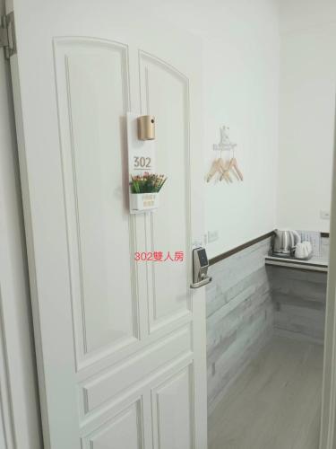 a white door in a room with a kitchen at Xiaomi Courtyard B&B in Chishang