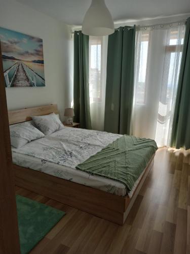 a bedroom with a large bed with green curtains at Sunny Hill Sandanski in Sandanski