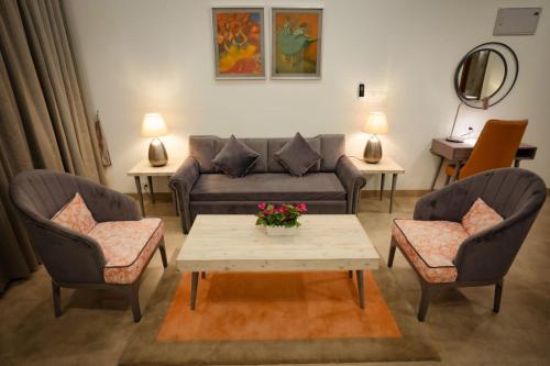 a living room with a couch and two chairs and a table at Carnival De Goa in Nerul