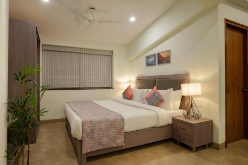ein Schlafzimmer mit einem großen Bett und einem Fenster in der Unterkunft Carnival De Goa in Nerul