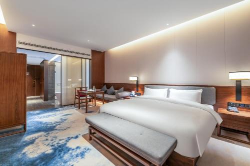 a bedroom with a large bed and a living room at Jinan Ziyue Meixiu Hotel in Jinan