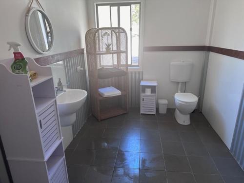 uma casa de banho com um lavatório e um WC em Wallaby Lodges em Pokolbin