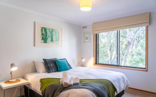a bedroom with a large bed and a window at The Escarpment in Halls Gap