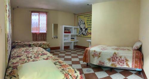 een slaapkamer met 2 bedden en een geruite vloer bij CASA BATZ #1 in San Pedro La Laguna