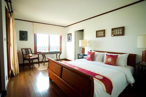 a bedroom with a large bed and a desk at Saigon Domaine Luxury Residences in Ho Chi Minh City