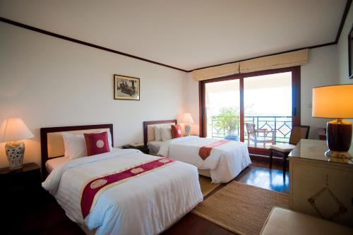 a hotel room with two beds and a balcony at Saigon Domaine Luxury Residences in Ho Chi Minh City